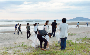 観音寺研究所近くの海辺を複数のBIKEN従業員が清掃してる写真
