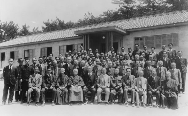 Group photo of the original 18 staff members at the establishment of the Kanonji Institute